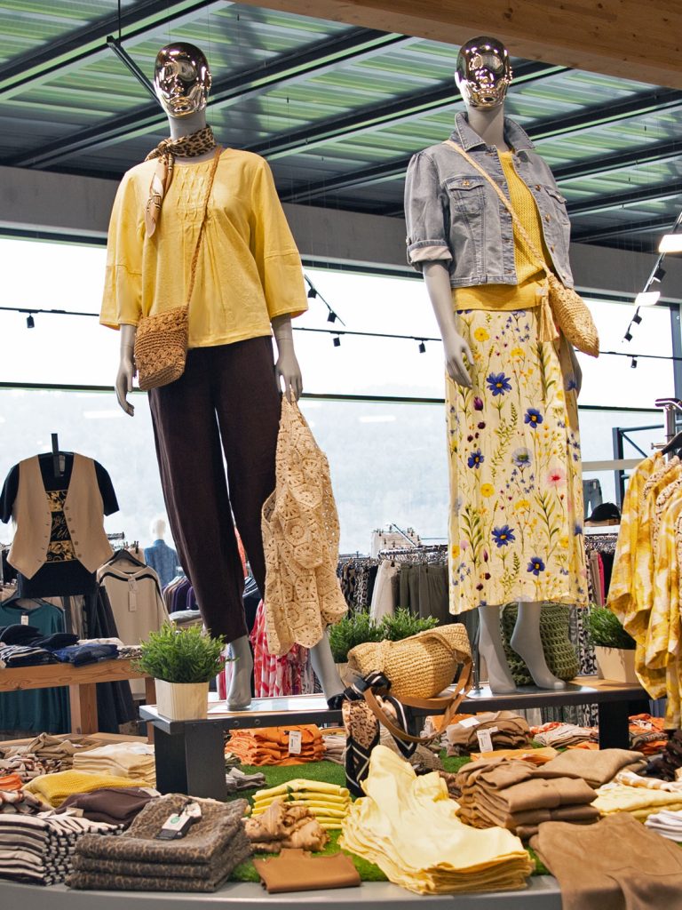 Hielscher Modehaus Frühjahrsmode 2026 - Gelber Rock mit Blumenmuster, Jeans, Stohtaschen, gelber Pulli